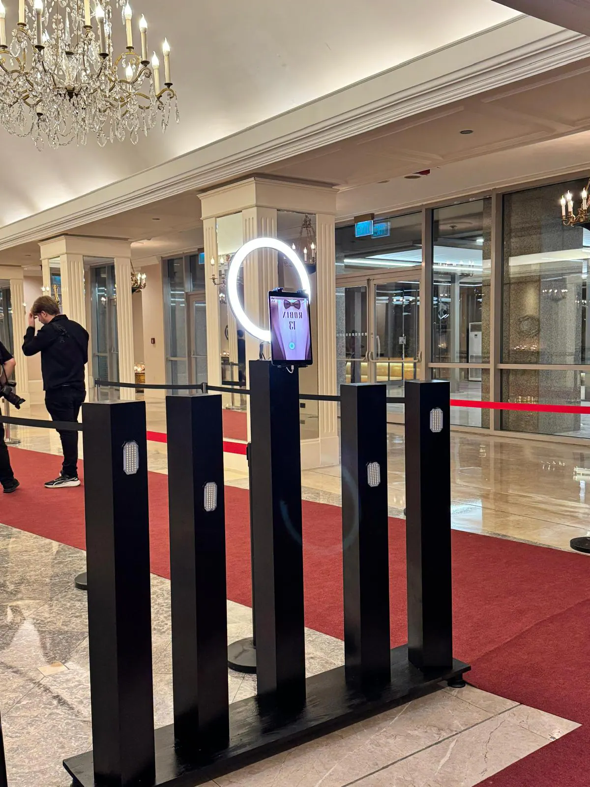 Kırmızı halı ve ışıklı kolonlarla kurulmuş Paparazzi Booth
